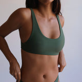 Woman wearing a green bikini against a plain background