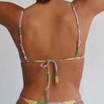 Person wearing a colorful bikini lying on a white surface