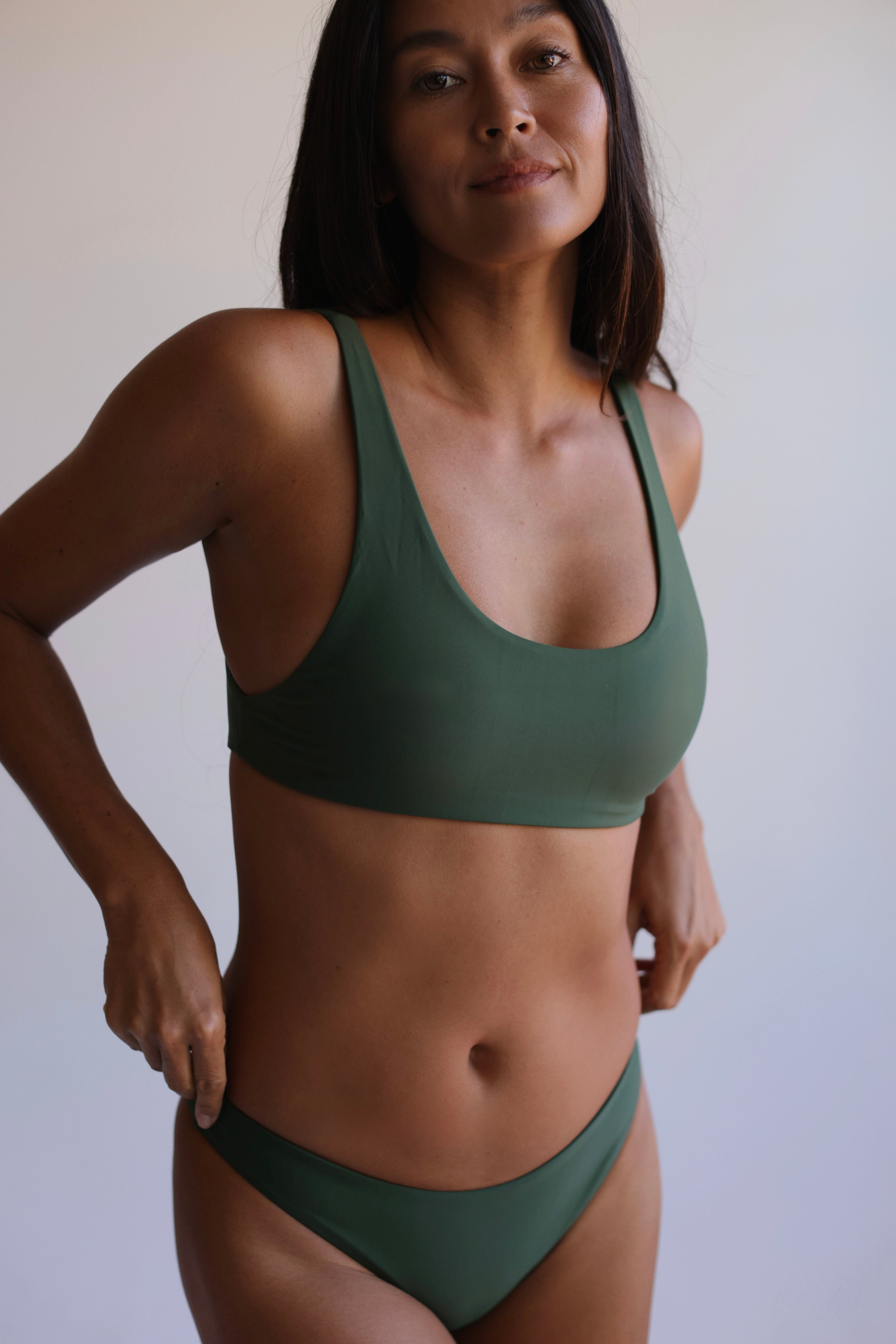 Woman wearing a green bikini against a plain background