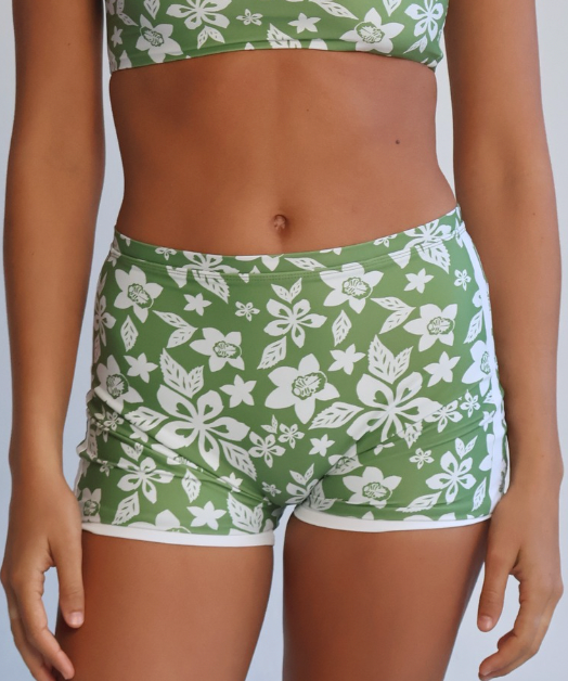 Person wearing a green and white floral bikini set against a plain background