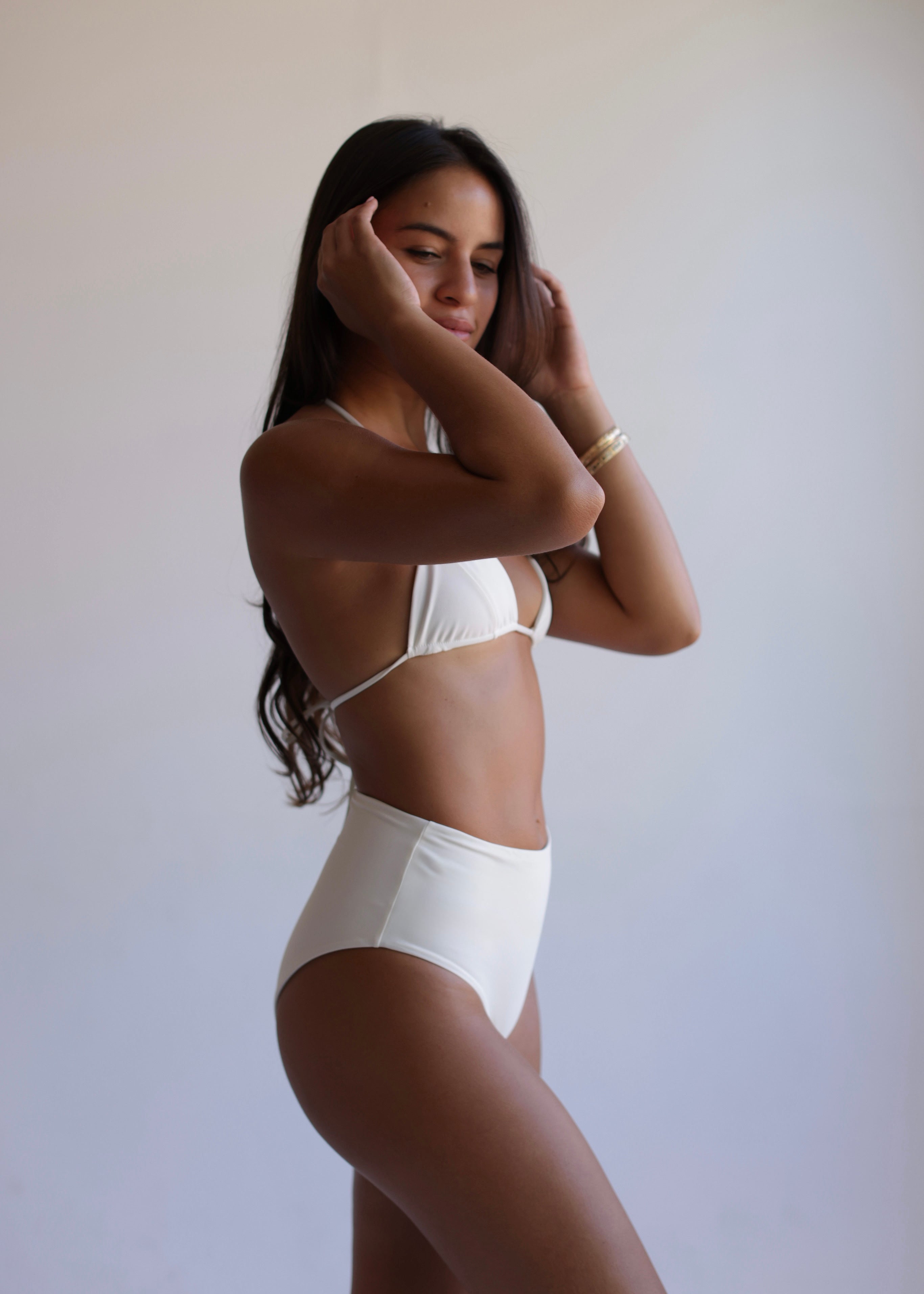 Woman wearing a white bikini against a plain background