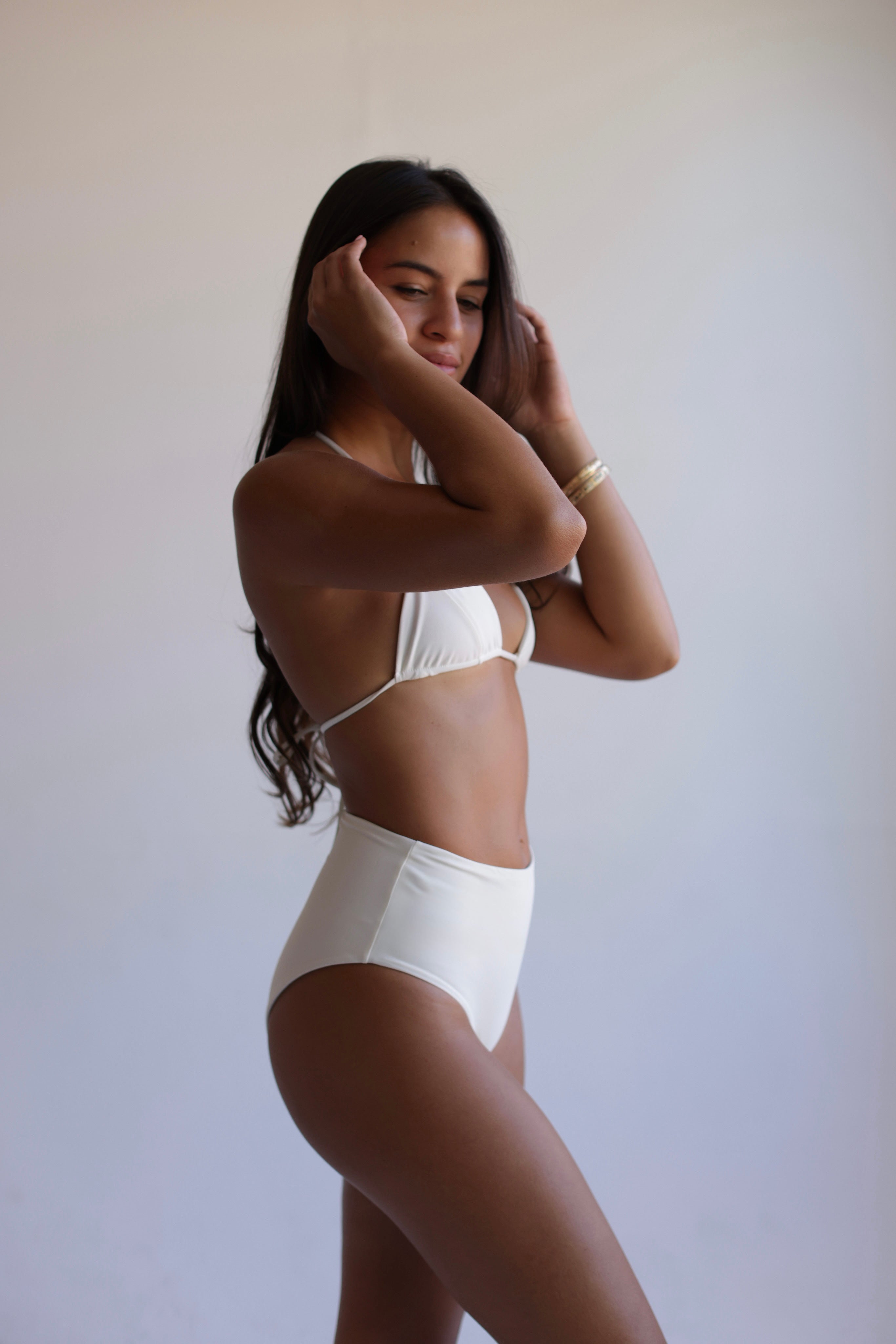 Woman wearing a white bikini against a plain background