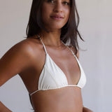 Woman wearing a white bikini against a plain background