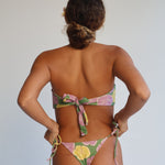Person wearing a colorful bikini with a neutral background