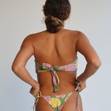 Person wearing a colorful bikini with a neutral background
